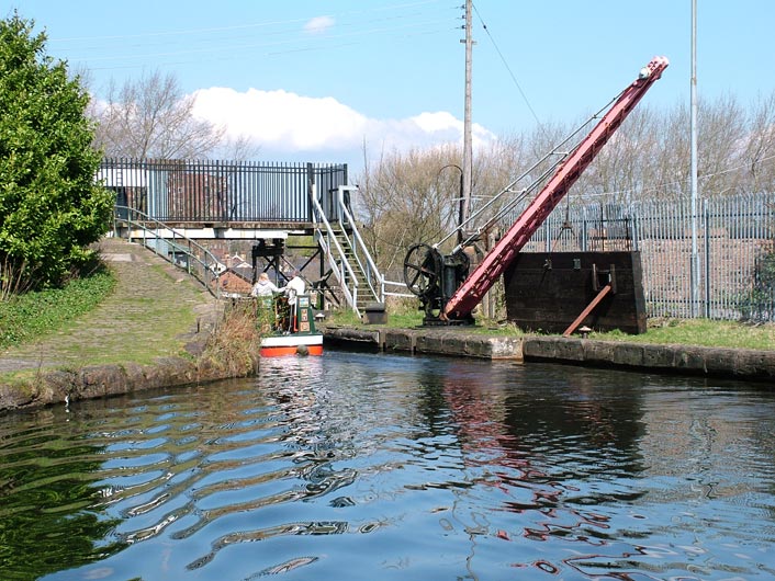 A boat enters Barton Swing Aqueduct bridge